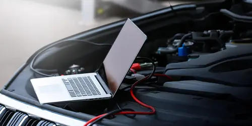 Laptop connected to vehicle OBD port for module programming